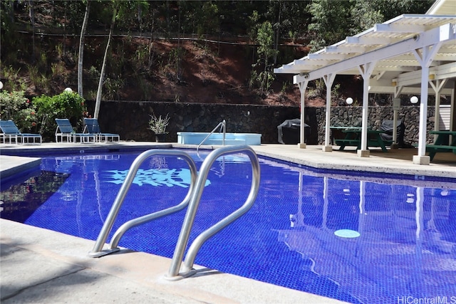 view of pool with a pergola and a grill