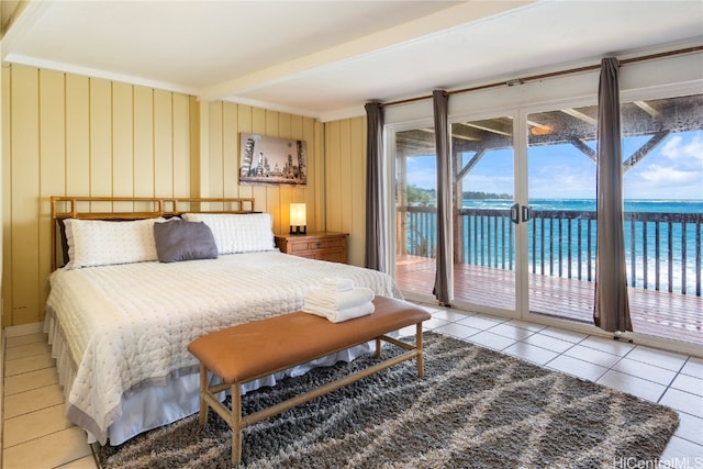 bedroom with beamed ceiling, a water view, access to outside, and light tile patterned floors