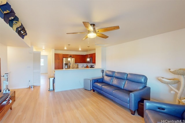 living room with ceiling fan and light hardwood / wood-style flooring