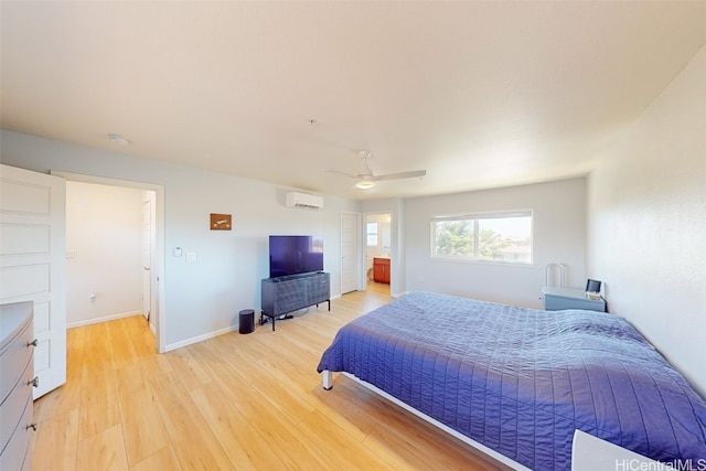 bedroom with ceiling fan, a wall mounted air conditioner, and light hardwood / wood-style floors