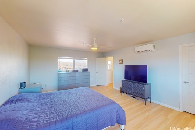 bedroom with light hardwood / wood-style flooring, a wall mounted AC, and ceiling fan