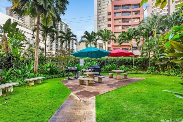 view of property's community with a lawn and a patio