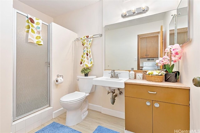 bathroom featuring hardwood / wood-style flooring, sink, toilet, and walk in shower