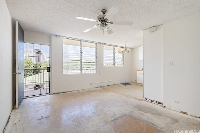 unfurnished room with ceiling fan with notable chandelier and a textured ceiling