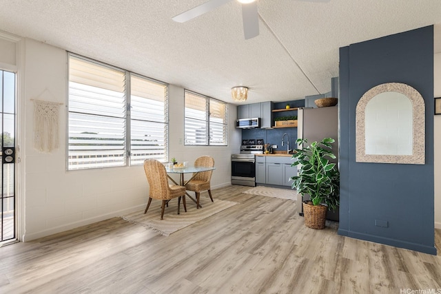 24 Hialoa St Unit 41, Honolulu, HI 96817 - dining space with concrete block wall, ceiling fan, light wood finished floors, and a textured ceiling