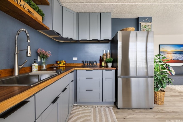 24 Hialoa St Unit 41, Honolulu, HI 96817 - kitchen featuring a sink, light wood finished floors, butcher block countertops, freestanding refrigerator, and gray cabinetry