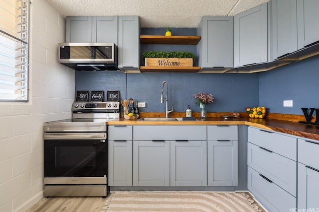 24 Hialoa St Unit 41, Honolulu, HI 96817 - kitchen featuring stainless steel appliances, light wood finished floors, wood counters, and a textured ceiling