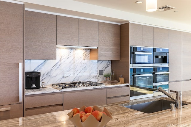 kitchen with light stone counters, tasteful backsplash, and appliances with stainless steel finishes