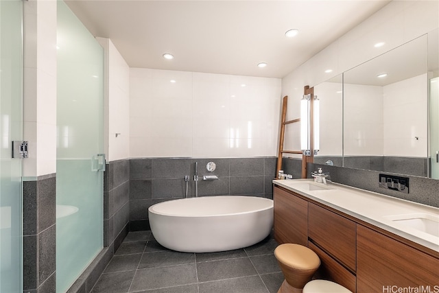 bathroom featuring vanity, tile walls, independent shower and bath, and tile patterned flooring