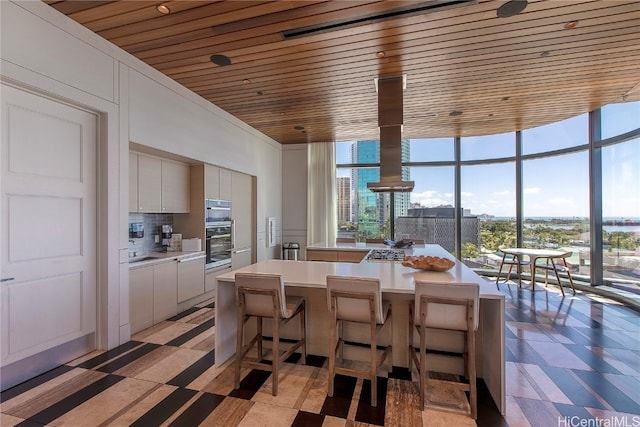 dining space with wood ceiling and a wall of windows