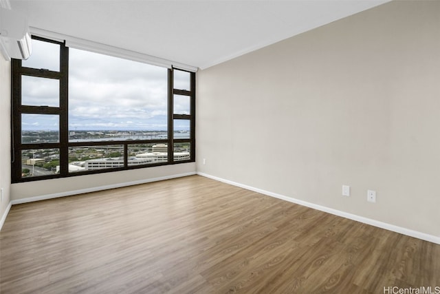 unfurnished room featuring hardwood / wood-style flooring and an AC wall unit