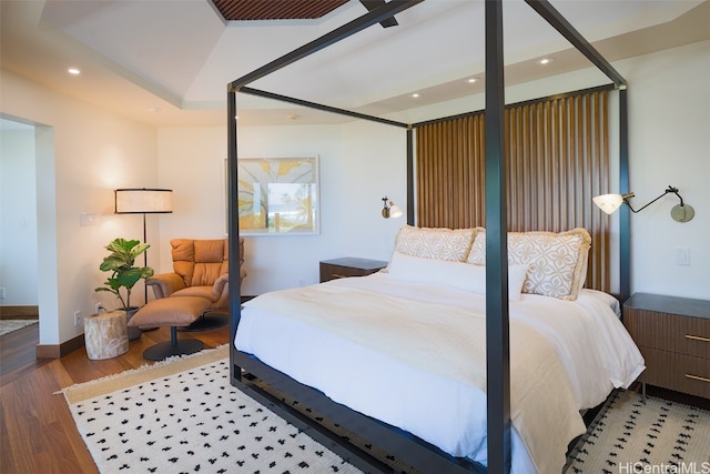 bedroom with vaulted ceiling and hardwood / wood-style flooring