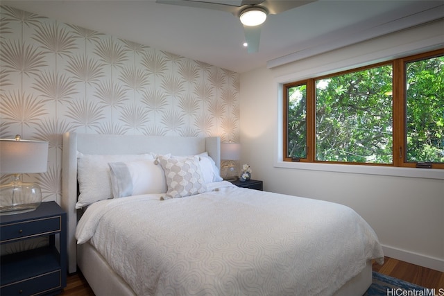 bedroom with dark hardwood / wood-style flooring and ceiling fan