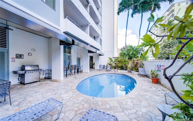 view of swimming pool featuring area for grilling and a patio area