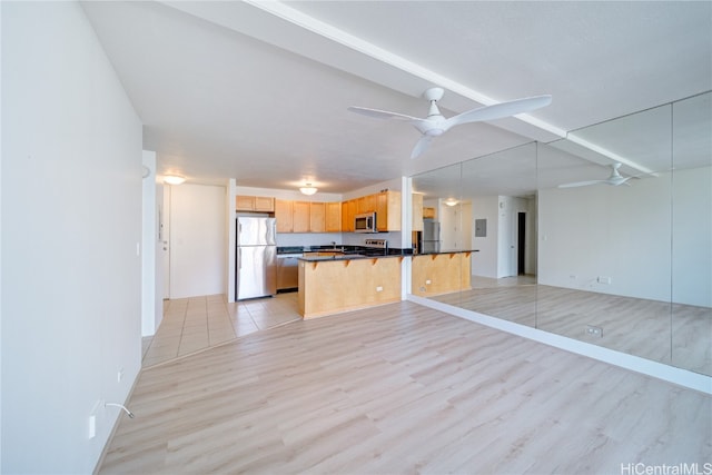 kitchen with ceiling fan, light brown cabinets, hanging light fixtures, stainless steel appliances, and light hardwood / wood-style floors