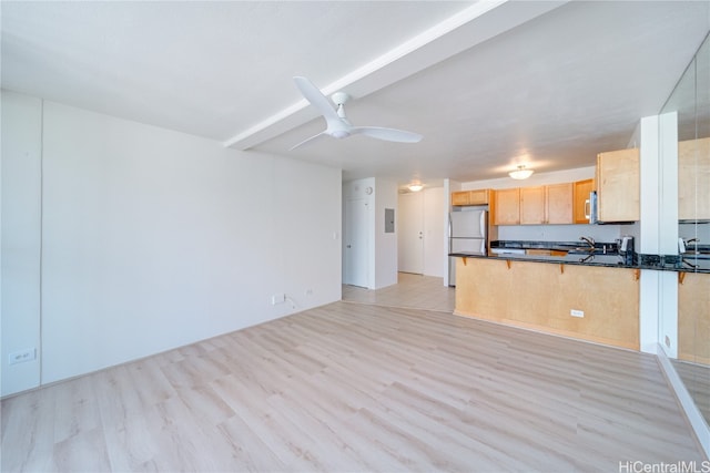 kitchen featuring light brown cabinets, sink, light hardwood / wood-style floors, kitchen peninsula, and stainless steel refrigerator