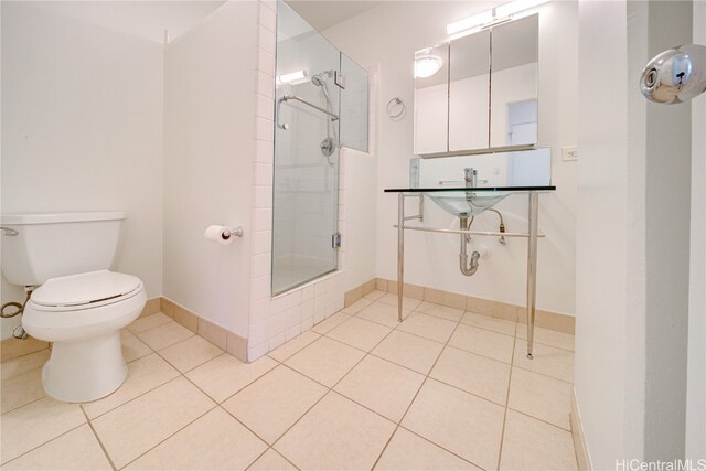 bathroom featuring tile patterned floors, sink, a shower with shower door, and toilet