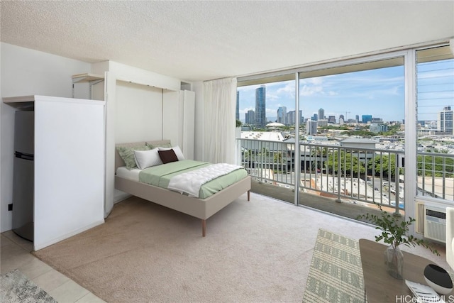 tiled bedroom with stainless steel fridge, a textured ceiling, access to exterior, and a wall of windows