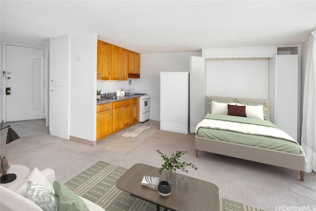 bedroom with light colored carpet and a textured ceiling