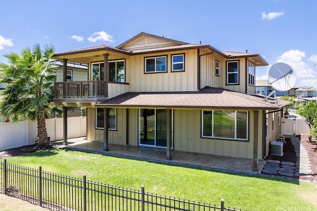 rear view of house with a patio, a balcony, central air condition unit, and a lawn