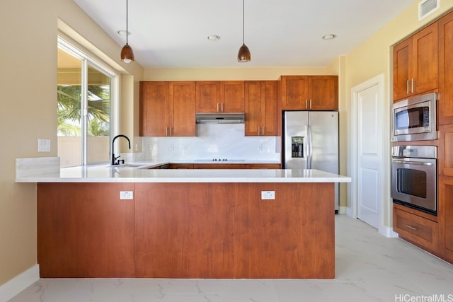 kitchen featuring sink, stainless steel appliances, decorative light fixtures, and kitchen peninsula