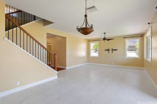 unfurnished living room with ceiling fan and a wealth of natural light