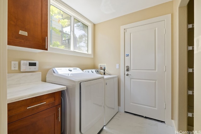 laundry room with washer and dryer and cabinets