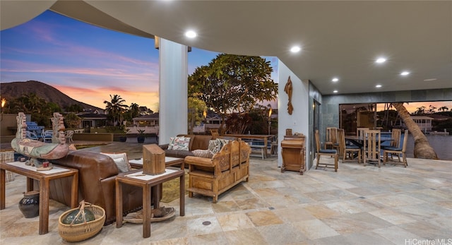 patio terrace at dusk featuring a mountain view and an outdoor hangout area