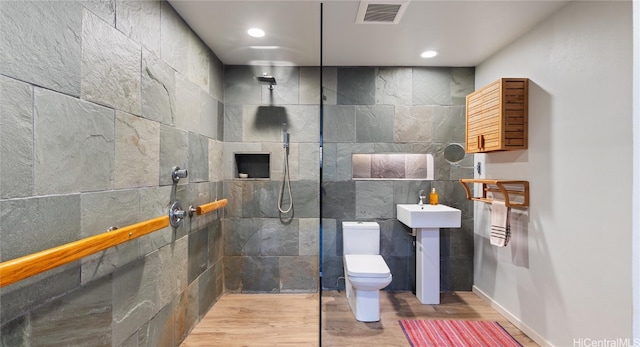 bathroom featuring toilet, tile walls, hardwood / wood-style floors, sink, and walk in shower