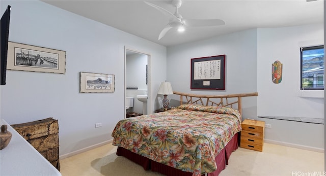 bedroom featuring light colored carpet, ceiling fan, and ensuite bath