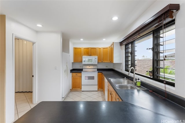 kitchen with light tile patterned floors, white appliances, and sink