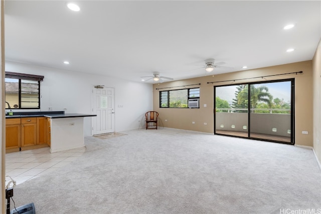 unfurnished living room with light colored carpet and ceiling fan