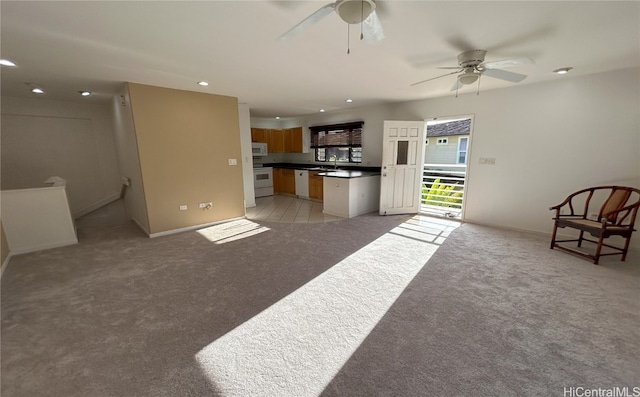 carpeted living room with sink and ceiling fan