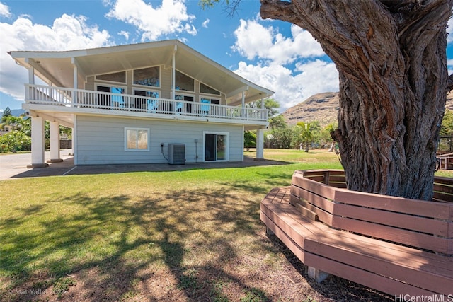 back of property with a patio area, central AC, a lawn, and a mountain view