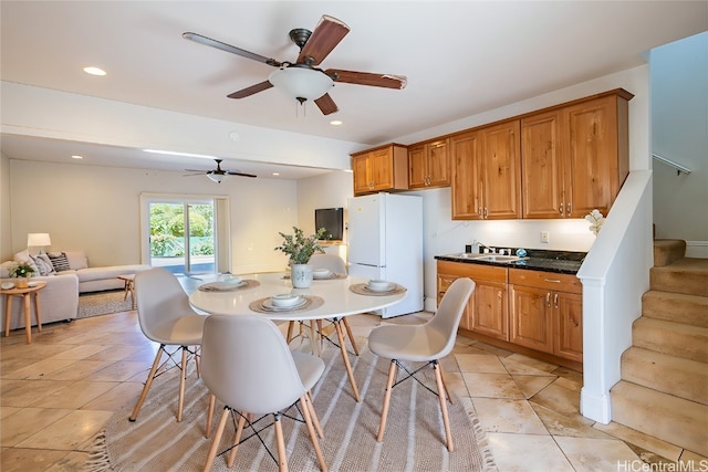 dining space featuring light tile patterned flooring, sink, and ceiling fan