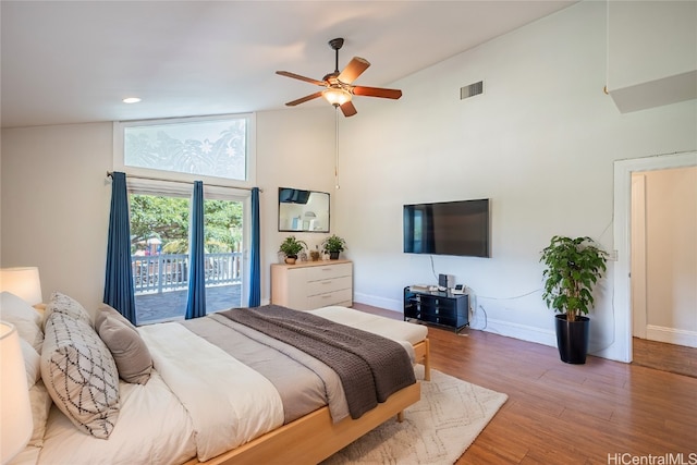 bedroom featuring hardwood / wood-style floors, ceiling fan, high vaulted ceiling, and access to outside