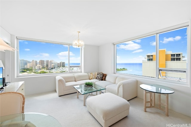 carpeted living room with an inviting chandelier and a water view