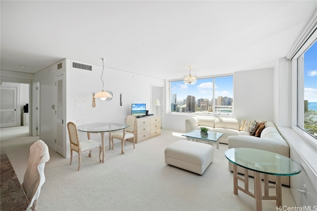 living room with a notable chandelier, carpet floors, and plenty of natural light