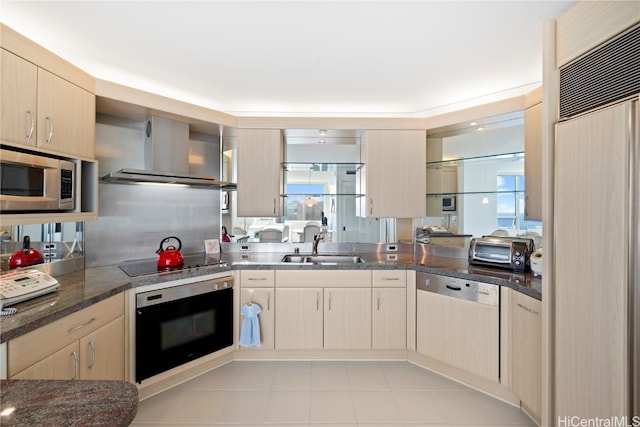 kitchen with light brown cabinets, wall chimney exhaust hood, built in appliances, kitchen peninsula, and sink