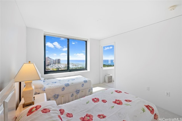 bedroom with an AC wall unit and light colored carpet