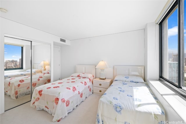 bedroom with light carpet and a closet