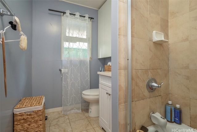 bathroom featuring toilet, vanity, a tile shower, and tile patterned flooring