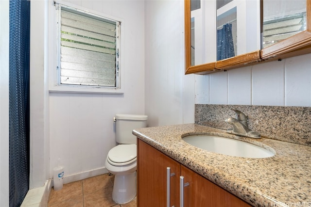 bathroom with vanity, toilet, tile patterned floors, and walk in shower