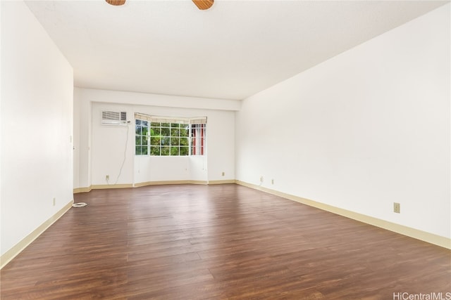 spare room with an AC wall unit and dark wood-type flooring