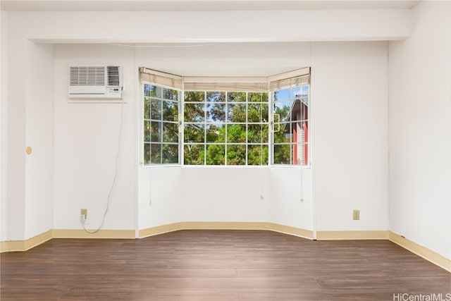 unfurnished room with a wall mounted AC and dark hardwood / wood-style flooring