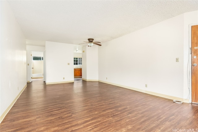 unfurnished living room with dark wood-type flooring, a textured ceiling, and ceiling fan