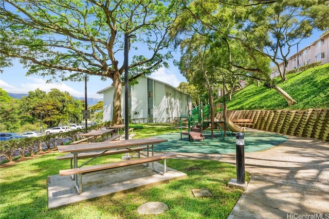 view of property's community with a lawn and a playground