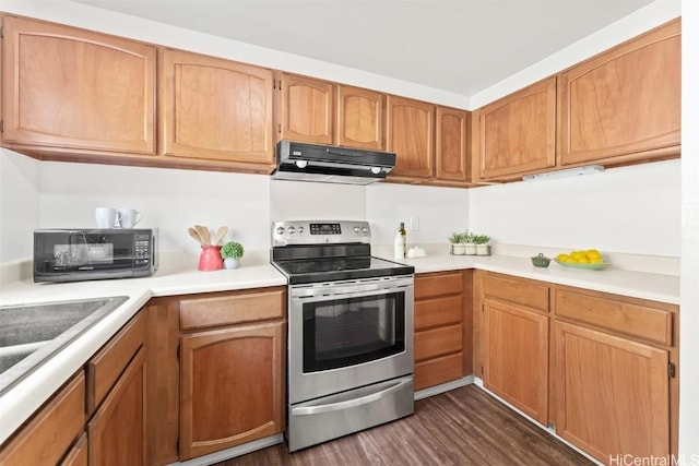 kitchen with stainless steel electric range oven, light countertops, dark wood-style flooring, and range hood