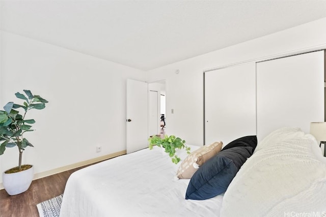 bedroom featuring a closet, wood finished floors, and baseboards