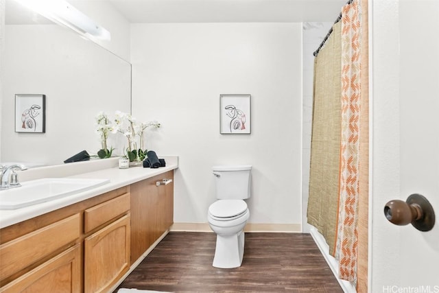 bathroom featuring toilet, wood finished floors, vanity, baseboards, and a shower with curtain